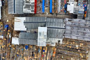 Drone view of destructed roofs of small shabby houses located in dirty district on sunny day
